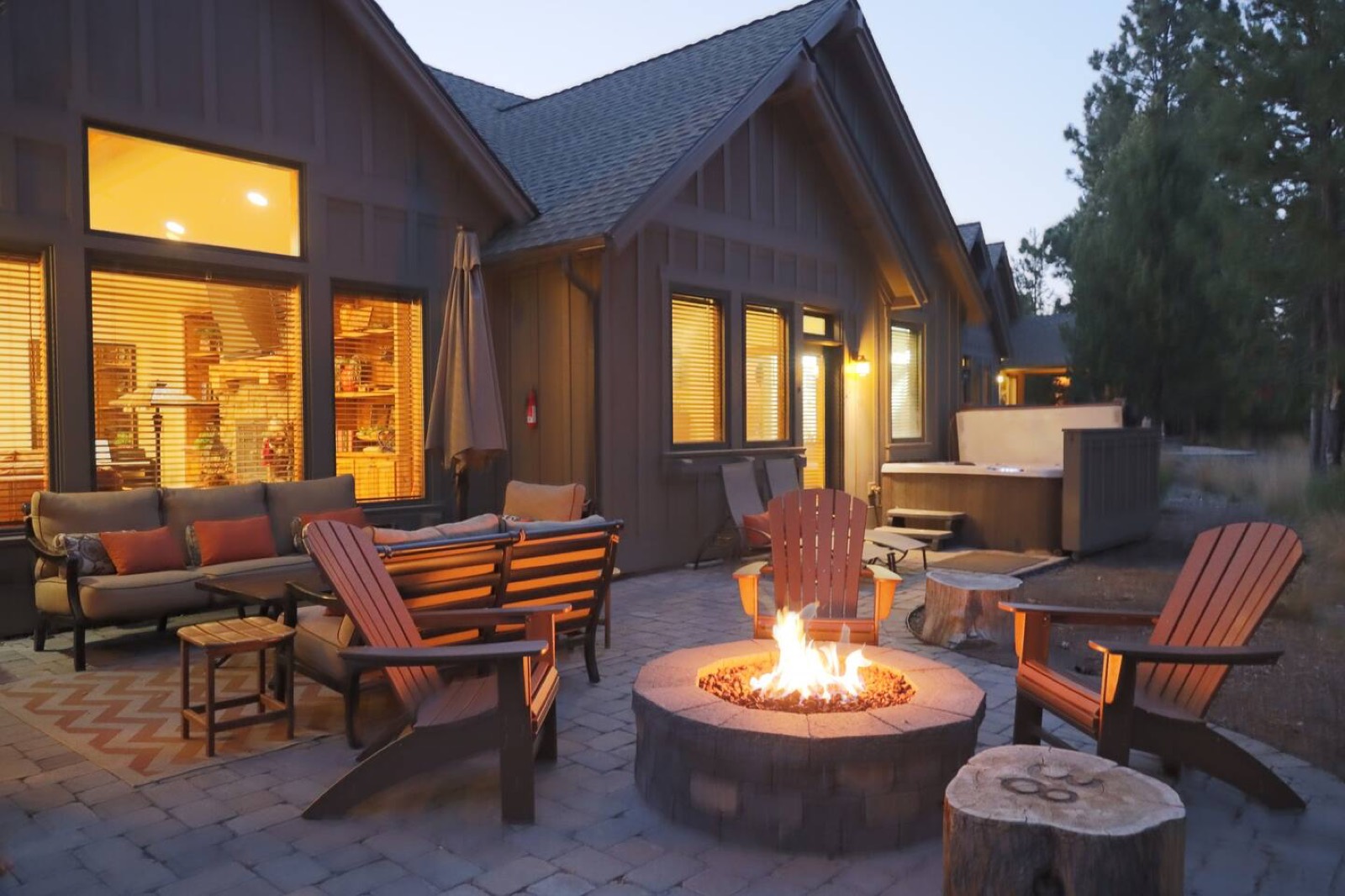 Back patio with a gas fire pit, dining table, barbecue and hot tub