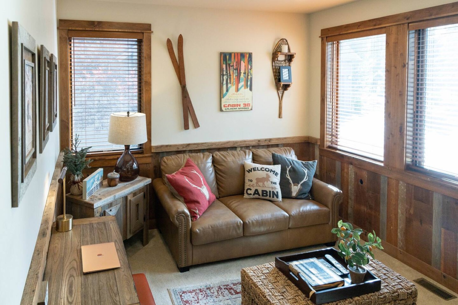 Office with a desk, sofa bed and television
